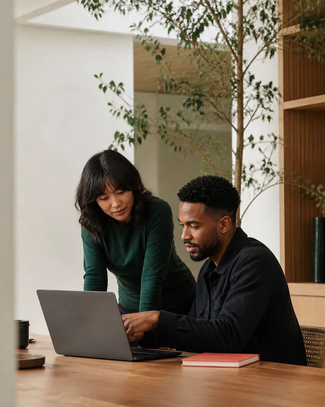 Two professionals working together on a laptop